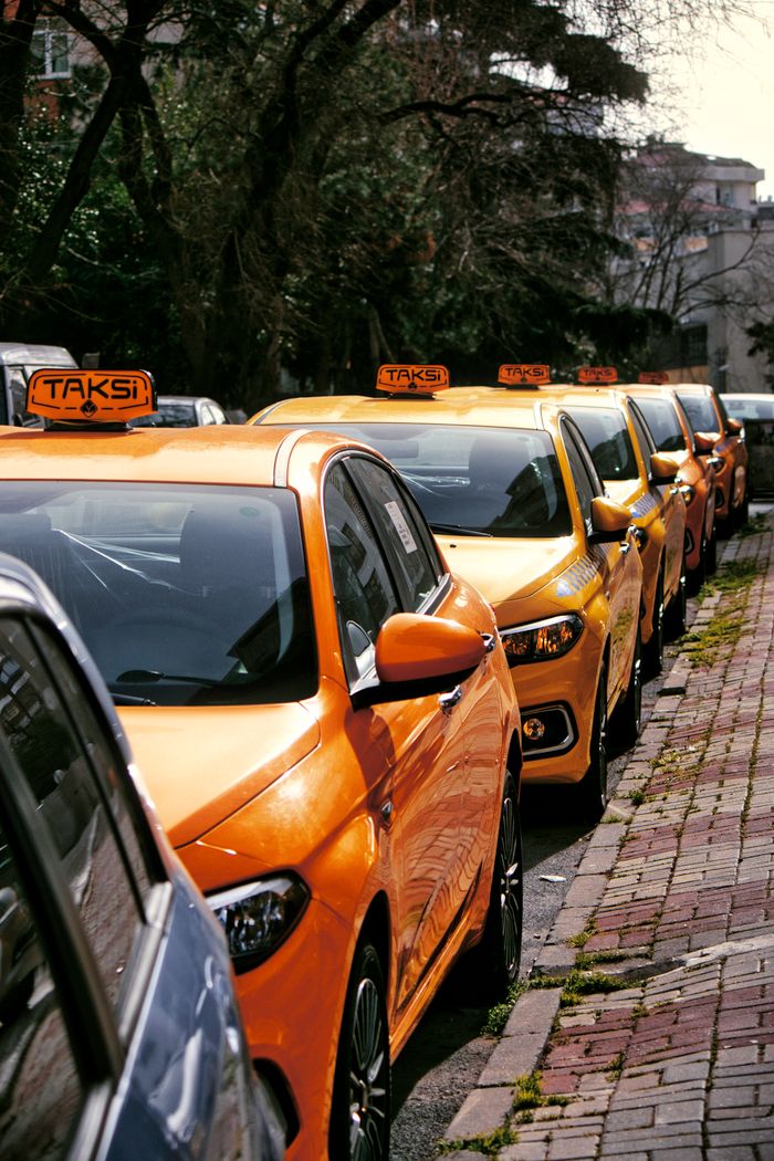 contact-img Close-up of multiple yellow taxis on a cobblestone street, hinting at lively urban transportation.